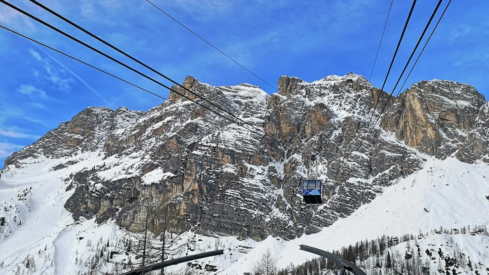 La cabina della funivia del Faloria sale verso le pareti innevate sopra Cortina
